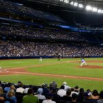 Juego de béisbol bajo las luces de un estadio